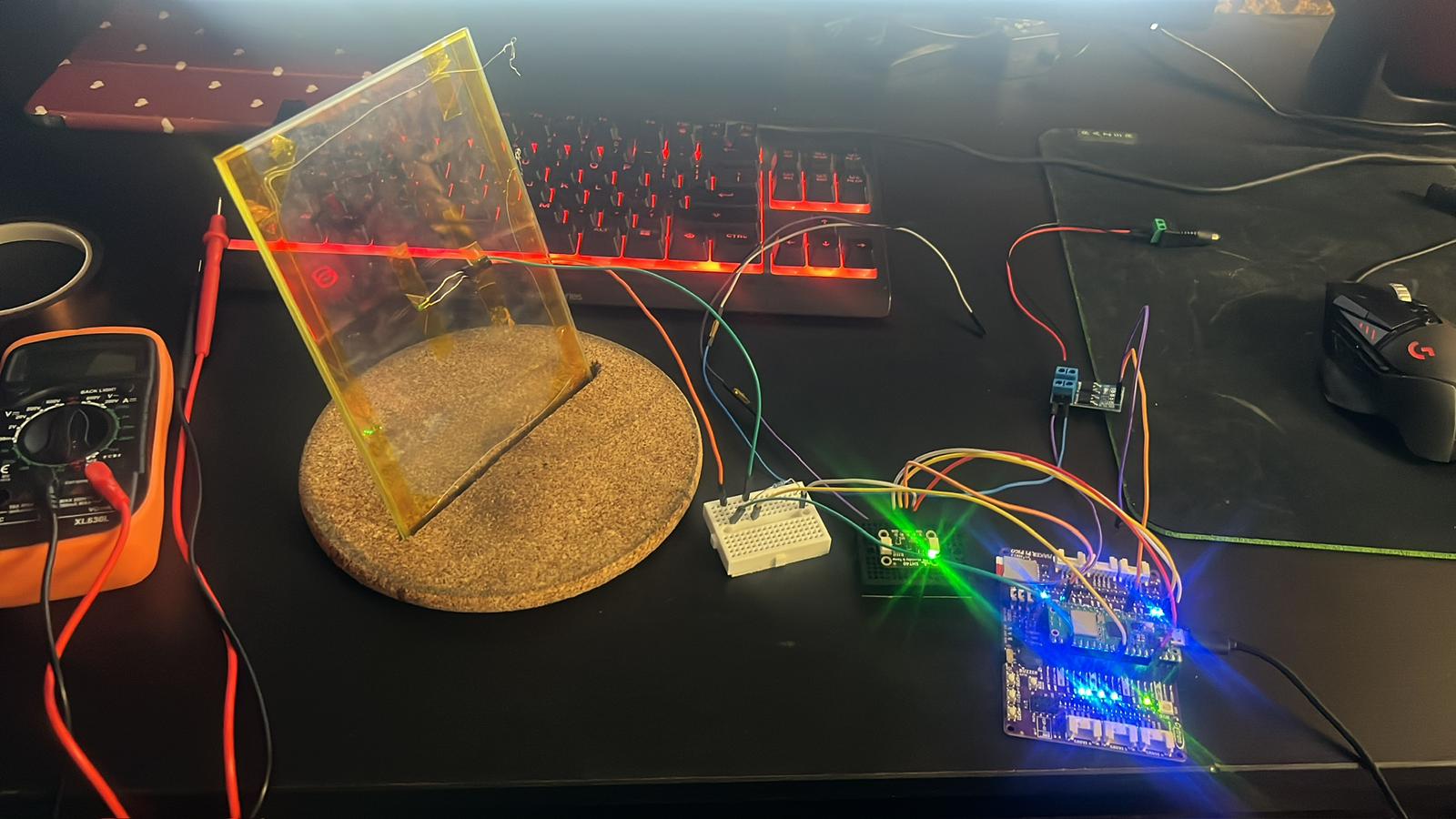 Electronics desk with breadboard, microcontroller, and multimeter