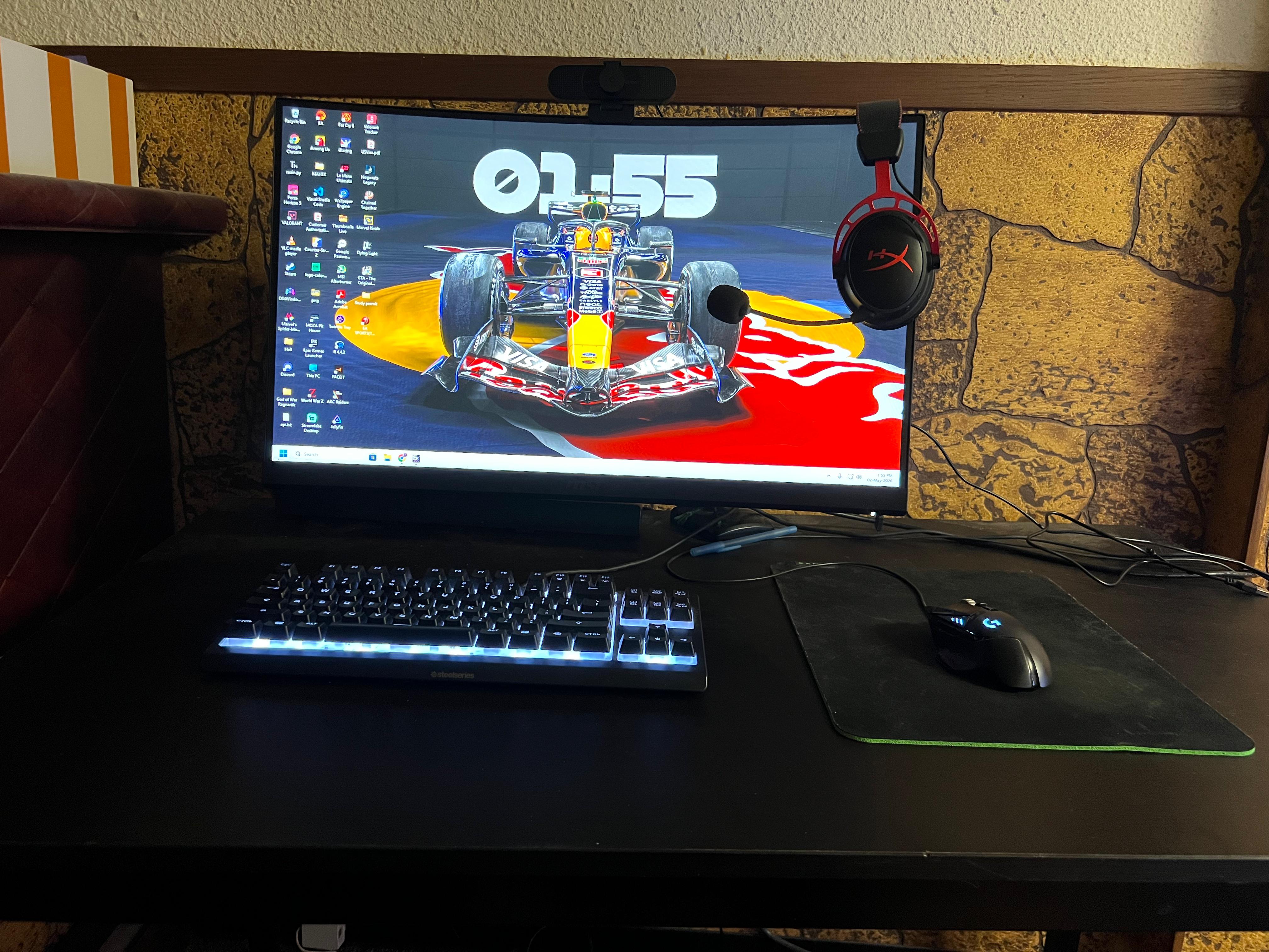 Gaming desk setup with monitor, keyboard, and headset